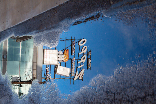 World famous Zippo sign reflection in a water puddle street photography, abstract copy space image, USA manufacturing theme