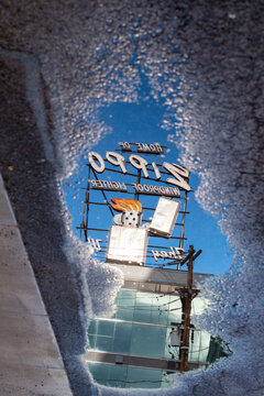 World famous Zippo sign reflection in a water puddle street photography, abstract copy space image, USA manufacturing theme