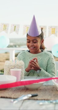 Happy, birthday and child with cake and applause for celebration, gathering and special day outdoor. Family, excited and girl with candles, balloons and streamers for cheering, milestone and dessert