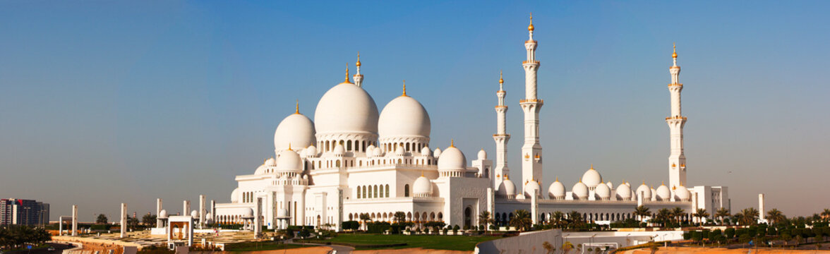 Majestic Sheikh Zayed Grand Mosque in Abu Dhabi, a stunning landmark of Islamic architecture with white domes and tall minarets.