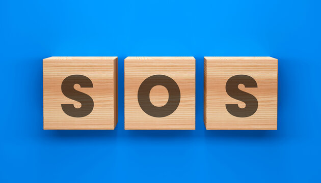 SOS: An eye-level shot captures a row of three wooden blocks, each displaying a letter, spelling out the universal distress signal SOS against a vibrant blue background.