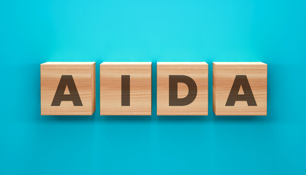 AIDA Marketing Concept: Wooden blocks spell out the acronym AIDA on a vibrant turquoise background. A straightforward representation of the core principles of marketing.