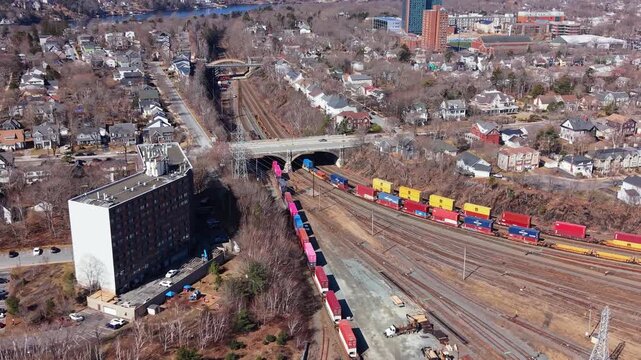 Aerial View Freight Train Carrying Containers Along Busy Railway Halifax Nova Scotia Canada Passing Residential Houses And Bridges Industrial Logistics Transportation Scene