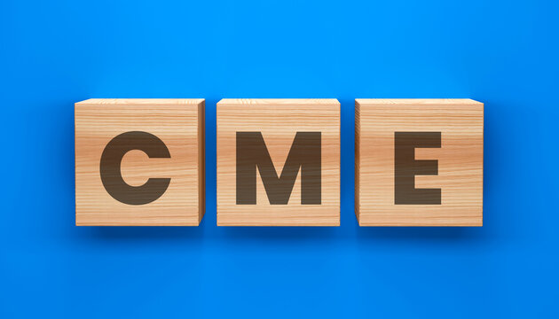 CME Word Blocks: A close-up shot of three wooden blocks, each showcasing a letter from CME set against a vibrant blue backdrop. Perfect for illustrating concepts of abbreviation, education.