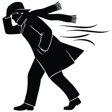  Man silhouette walking against strong wind with a coat and scarf
