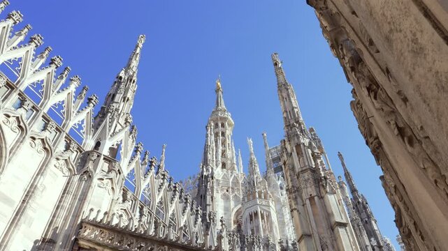 Nice view of Milan Madonnina and marble statues at sunny day background blue sky, duomo cathedral rooftop view point,Milan, Italy