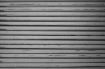 Obraz premium building is lined with square panels. metal sheet wall cladding with scalloped design. corrugated sheet, dark gray, riveted. horizontal stripes, shadows, corner, fence, aluminium, sheet
