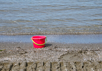 red pail on the water's edge © saturno