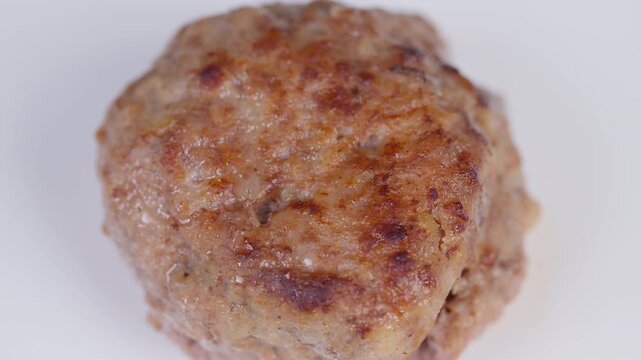 Homemade meat patty. Golden crispy homemade meat patty. Closeup of freshly cooked meat patty. Close examination of goldenbrown homemade meat cutlet on white background