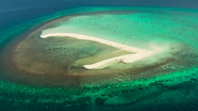 Beautiful beach on tropical island surrounded by coral reef, sandy bar with tourists, top view. Sandbar Atoll. Summer and travel vacation concept, Camiguin, Philippines.