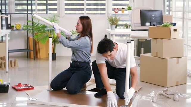 Young couple installing furniture at home.assemble furniture. Moving in new house. Self-assembly furniture concept.