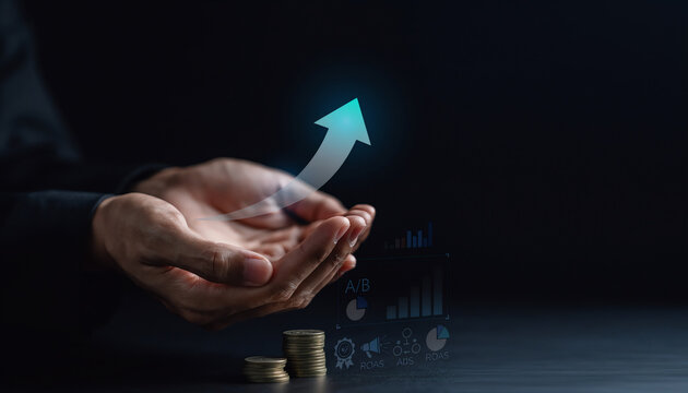 Hand holding rising arrow with business growth charts