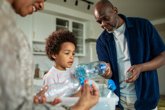 Family recycling plastic bottles in home kitchen