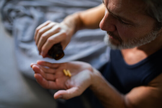 Middle-aged man taking vitamin pills at home