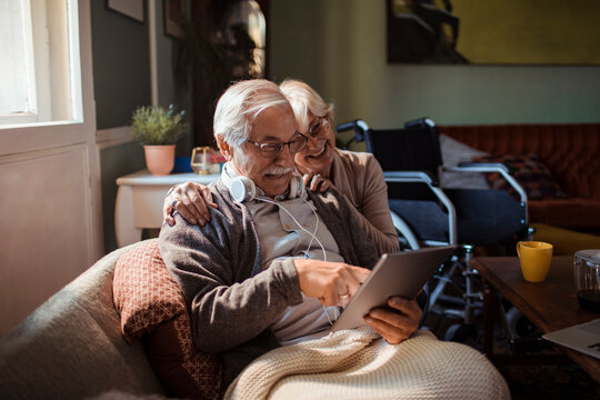 Smiling senior couple using tablet at home