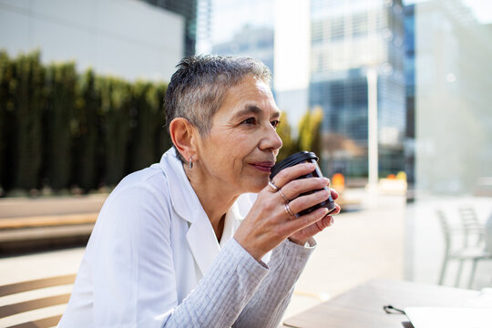 Senior woman enjoying coffee at outdoor city cafe