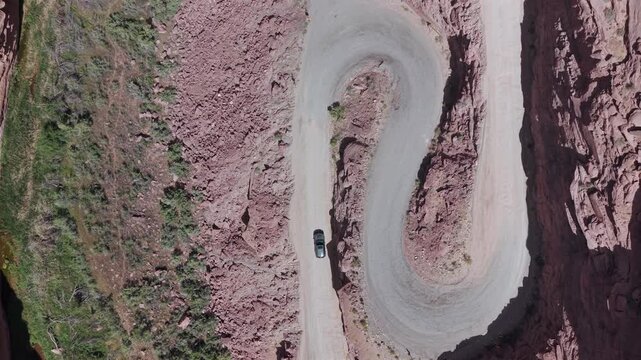 Moab Utah Car on Switchback Aerial Drone Shot Rising Between Rock Faces 4K