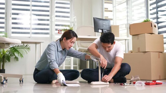 Self-assembly furniture concept. Young couple moving into new apartment or assembly furniture .