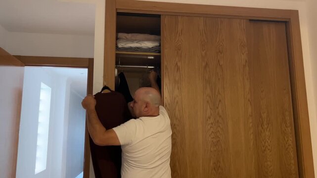 Hombre escogiendo su ropa en el armario