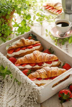 Croissants with strawberries and whipped cream, close-up. Breakfast .table with croissants  and coffee 