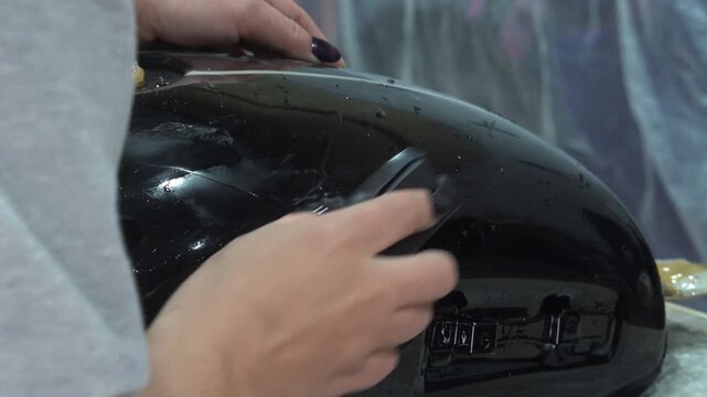 Worker Applying Protective Film On Car Body Surface Repair