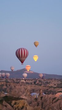 Experience the magic of Cappadocia Turkey as vibrant hot air balloons ascend among unique rock formations at dawn, creating an enchanting display against the early morning sky.