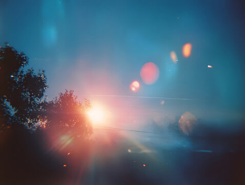 Sunset lens flare overexposed light leak dreamy film aesthetic sunset lens flare light leak dreamy film sky tree silhouette sun glow haze bokeh flare evening warm light blue sky horizon nature
