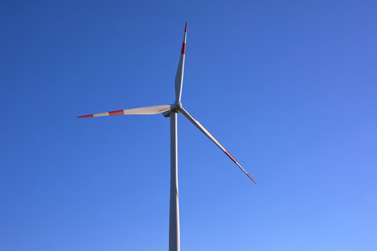 Wind turbines at sunset in green field &ndash; renewable energy, clean power, sustainable future.