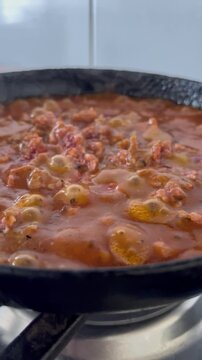 Bubbling homemade tomato sauce simmering in a frying pan