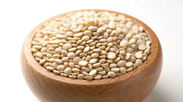 Close-up of Split Dried Urad Dal Lentils in a Wooden Bowl on White Background