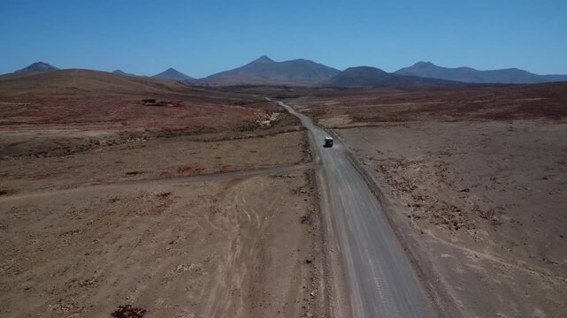Mountains of Fuerteventura with gravel road and camper van driving