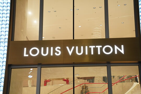 Louis Vuitton brand logo on a luxury storefront window.