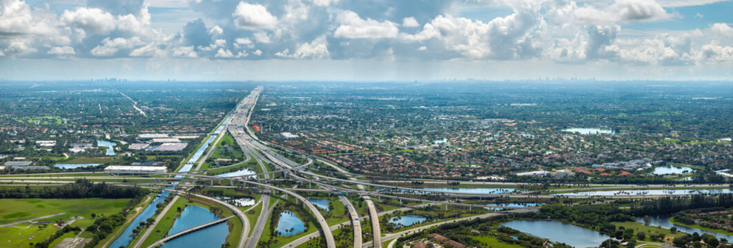 Aerial view of American freeway intersection with fast driving cars and trucks in Miami, Florida. USA city transportation infrastructure