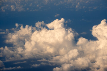 Obraz premium Cloudy sky, from airplane window point of view. View from above at high altitude of dense puffy cumulus clouds
