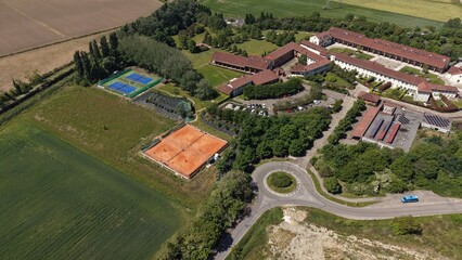 Fototapeta premium Aerial drone shot of a restored borgo in San Donato Milanese near Milan. Historic buildings with preserved design are integrated into a modern residential complex
