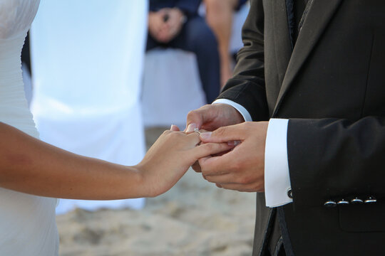 Novio le pone el anillo de boda a su novia en la boda. 
