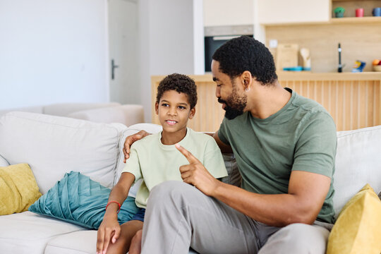 Portrait of a happy teenage boy son talking to his father at home. Sharing secrets and having fun, support and parenthood concept