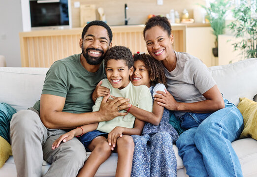 Portrait of a happy black family mother father and kids at home on couch