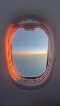 View of plane window by sunset during flight