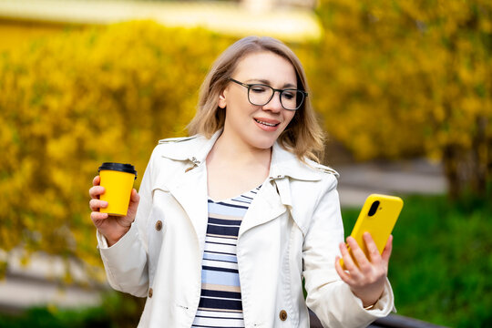 Woman with coffee cup and smartphone. Fresh aroma, cheerful spirit and perfect beginning of day.