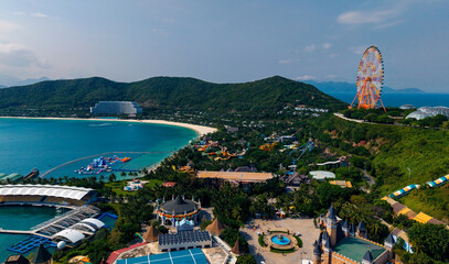 Obraz premium Aerial view of coastal amusement park with ferris wheel and beach, travel trip Nha trang, Vietnam