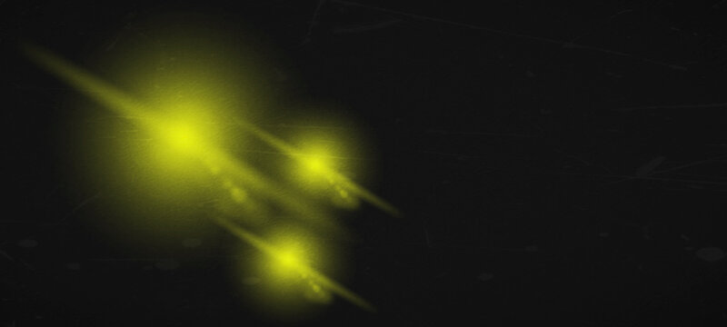 Triple yellow lens flare spots on dark background with cinematic light leak effect and film noise texture creating radiant sun glow for creative graphic design featuring vintage grunge surface details