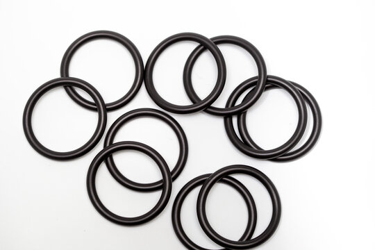Rubber O-rings sealing industrial components, used for leak prevention in plumbing and machinery, arranged on a clean white background&mdash;ideal reference for designers working on engineering, maintenance