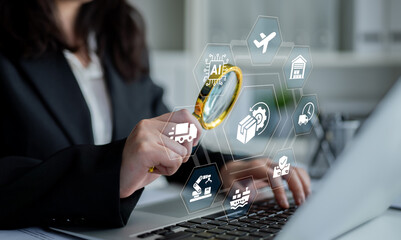 Naklejka premium A professional woman focuses on analyzing digital icons representing logistics and tech trends while using a magnifying glass over a laptop in an office environment. Ledger