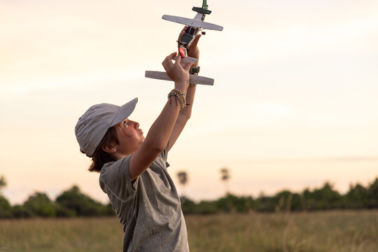 young boy "flying" wooden safari plane,Okavango Delta, Botswana, Africa