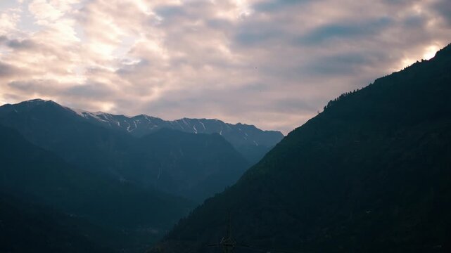 4K shot of clouds above the Himalayas during the sunset as seen from Naggar village near Manali in Himachal Pradesh, India. Scenic sunset background in the Himalayas. Natural sunset background. 