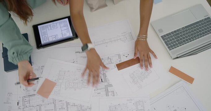 Diverse female coworkers starting with printed plans and tablet, placing swatches for design review