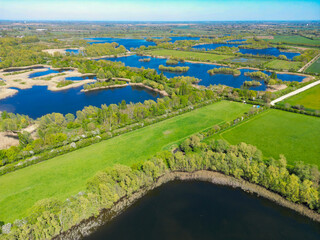Wonderful drone photography view of many lagoons and small lakes seen in the Fen Drayton reserve in Cambridgeshire, UK. In the far distance is the market town of St Ives. © Nick Beer