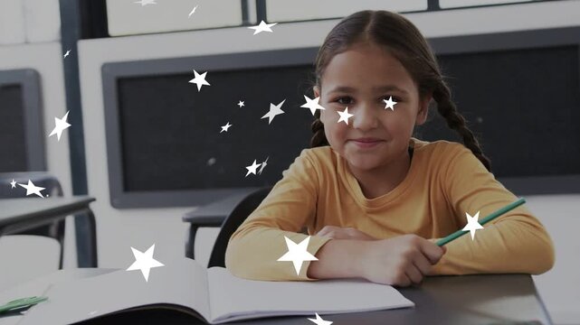 Girl at school desk moving green pencil while white stars appearing from start, smiling at stars