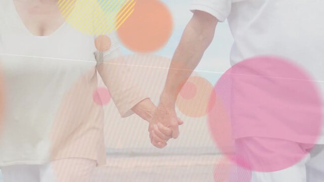 Senior couple walking beach holding hands for wellness, camera pulling back while circles layering